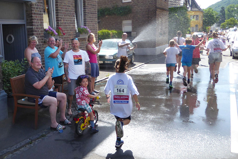 Nachbarn feuern Kinder beim Nachbarschaftslauf an
