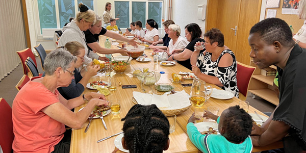 Große Gruppe mit jungen und alten Menschen Essen gemeinsam am Tisch